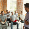 Several people are listening to a speaker at a workshop.